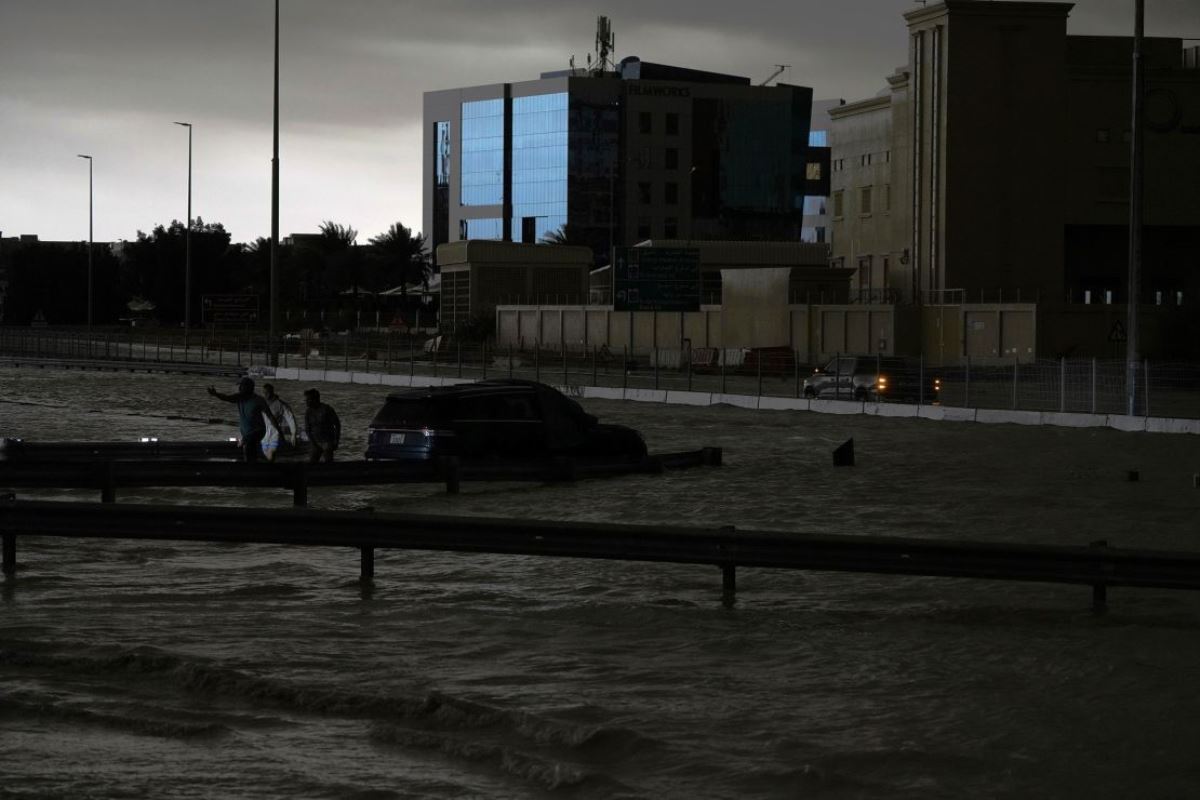 冠水した道路で車両をけん引しようとする人たち＝１６日、 アラブ首長国連邦（ＵＡＥ）ドバイ/Jon Gambrell/AP