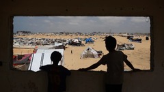 ガザ南部ラファの避難民用キャンプに立つパレスチナ人の子どもたち