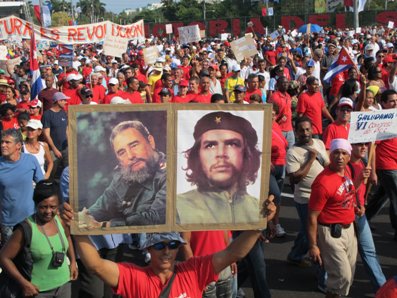 ４月に開催された共産党大会で、カストロ前国家評議会議長（左）と、キューバ革命の英雄チェ・ゲバラの肖像画を掲げる参加者