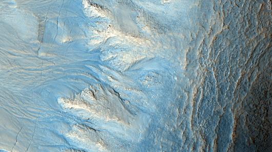 高解像度のＨｉＲＩＳＥカメラが火星の北半球で撮影した画像。水の流れによってクレーターに溝が形成された可能性がある