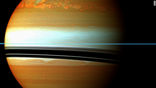 土星。赤、オレンジ、緑の雲状のものは２０１０年から１１年にかけて発生した大規模嵐の末端部分を示す＝ＮＡＳＡの提供写真