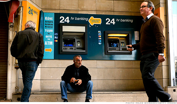 銀行のＡＴＭ（現金自動出入機）の前で腰を下ろす男性