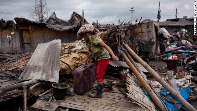 シナブン山付近に住む被災者が損壊した家の中から私物を探す