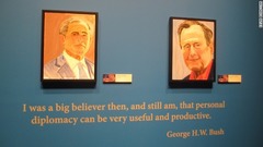 ブッシュ氏の自画像（左）と、父親のブッシュ元大統領の肖像画