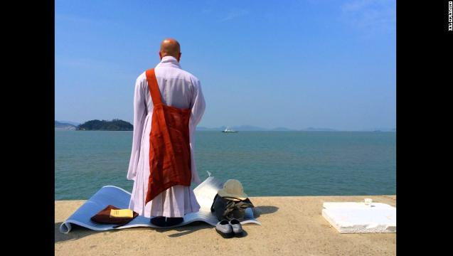 海に向かってお経を唱える僧侶。捜索活動では民間人ダイバーの中から死者が出た