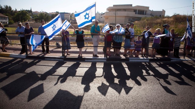 殺害されたイスラエル人少年の葬儀で国旗を掲げる人々