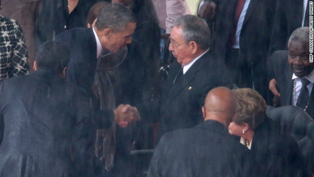 ２０１３年１２月のネルソン・マンデラ氏の追悼式で握手を交わす米・キューバの両首脳。国交正常化を米国民の６割が支持しているという
