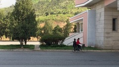 平壌からＤＭＺへと延びる高速道路上で、自転車に相乗りする女性２人。南へ向かっている