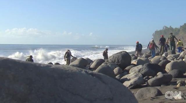 レユニオン島の海岸で残骸の捜索を続けるボランティアの人々