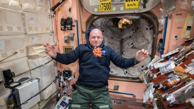 スコット・ケリー宇宙飛行士。ＩＳＳで人参を前に写真に納まる＝NASA