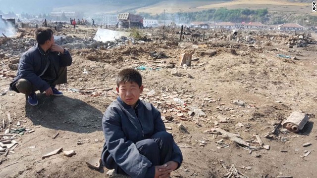 被害を受けた土地に座る少年＝咸鏡北道、ＵＮＤＰ