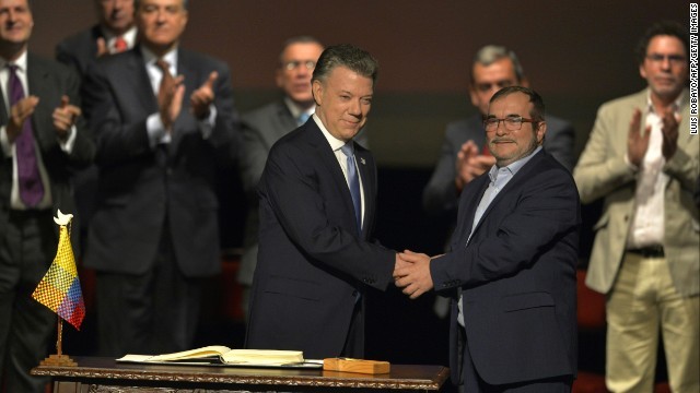 和平合意の署名式で握手するサントス大統領（左）とＦＡＲＣのロンドニョ最高司令官