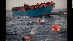 ８月２９日：地中海のリビア沖ですし詰め状態の木のボートから泳いで離れる移民ら