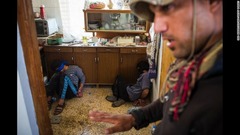１１月１１日：イラク・モスルの民家に隠れているのが見つかったＩＳＩＳの戦闘員とみられる２人。イラク特殊部隊員が警戒に当たる