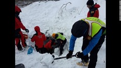 生存者を見つけるため雪をかきわける救助隊員