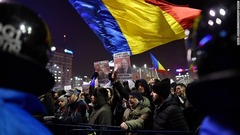 ルーマニアの国旗を振って抗議する人々。欧州委員会や周辺国から懸念を表明する声明が出された