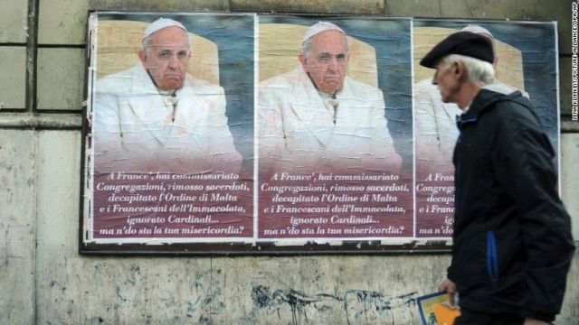 ローマ市内に掲示された法王批判のポスターを眺める男性