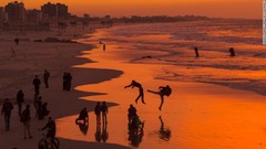 ガザ市：夕暮れ時の波打ち際で楽しむパレスチナの人々。ガザ市には約５０万人が暮らす