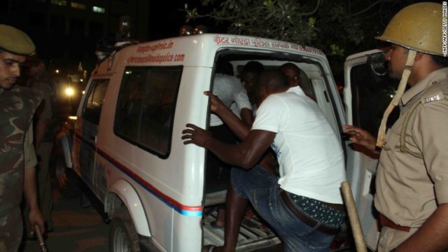 暴行の現場からアフリカ出身者らを搬送するインド警察