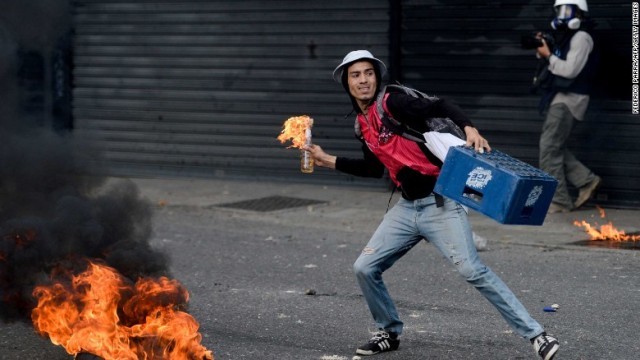 火炎瓶を手に持つ抗議デモの参加者。ベネズエラではデモに関係して２２人の死者が出ている