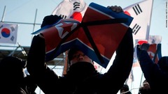試合会場の外では、北朝鮮の旗を破って抗議する人の姿も