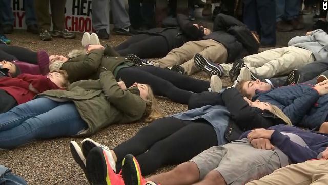 銃規制を求めて、ホワイトハウス前で地面に横たわり抗議する若者