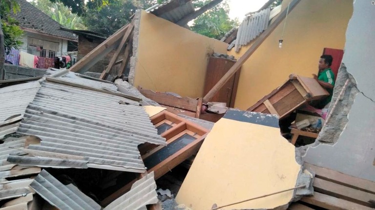 地震で損傷した家屋を調べる男性/AP