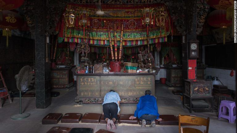台風の到達前に寺院で祈りをささげる人たち＝１５日、中国/Nicolas Asfouri/AFP/Getty Images
