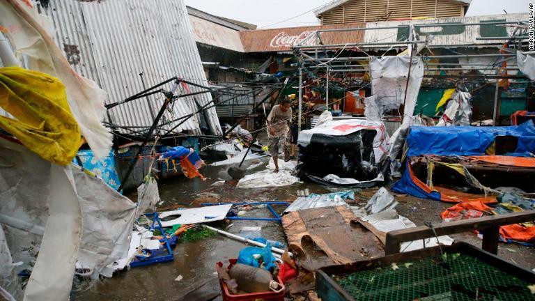 破損した建物の中を歩く住民＝１５日、フィリピン・トゥゲガラオ/Aaron Favila/AP