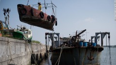 台風の襲来に備えて船を移す漁師＝１５日、中国・湛江市郊外