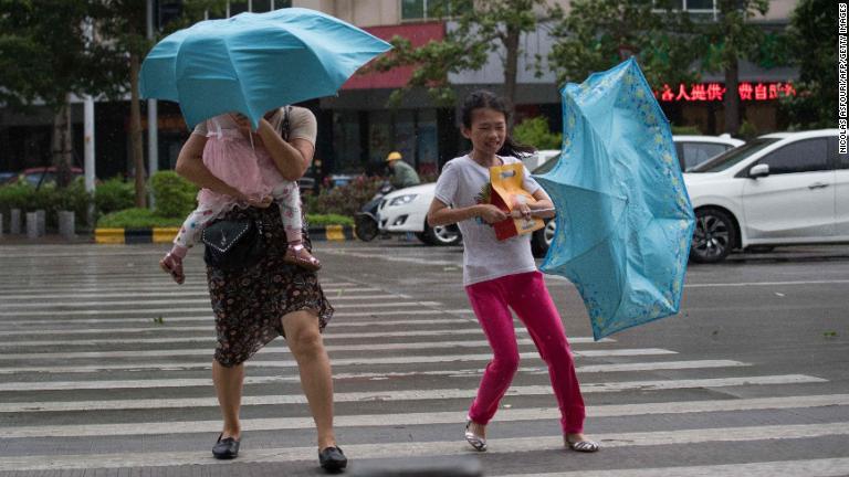 強風のなかを歩く人々＝広東省/Nicolas Asfouri/AFP/Getty Images