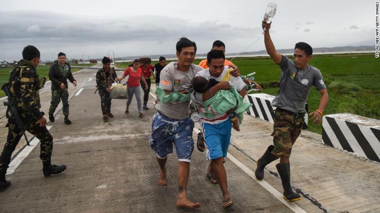 病気の子どもを搬送するフィリピン軍兵士＝１５日/Ted Aljibe/AFP/Getty Images