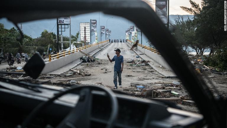破損した橋の写真を撮る男性＝１日、パル市/Carl Court/Getty Images