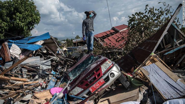 壊れた車両の上に立つ男性/Carl Court/Getty Images