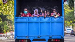 トラックに乗って避難する人々＝３日、インドネシア・パル市