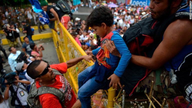 グアテマラからメキシコへ柵を越えて移される子ども/Oliver de Roos/AP