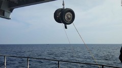 海中から引き上げられた車輪＝１１月２日