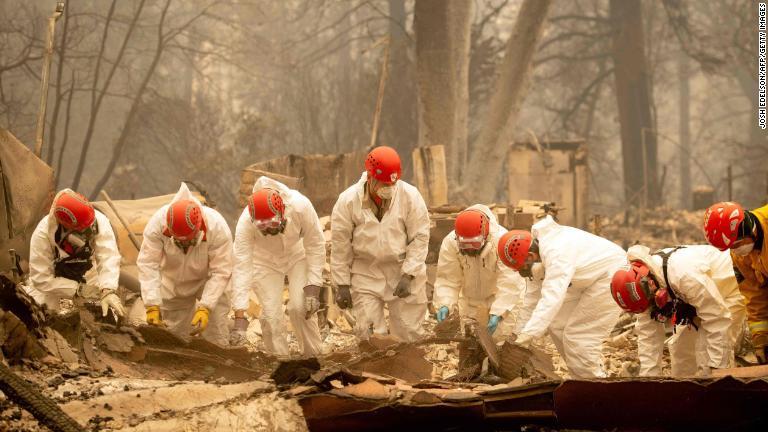 がれきの中で捜索を行う救急隊員＝１４日/Josh Edelson/AFP/Getty Images