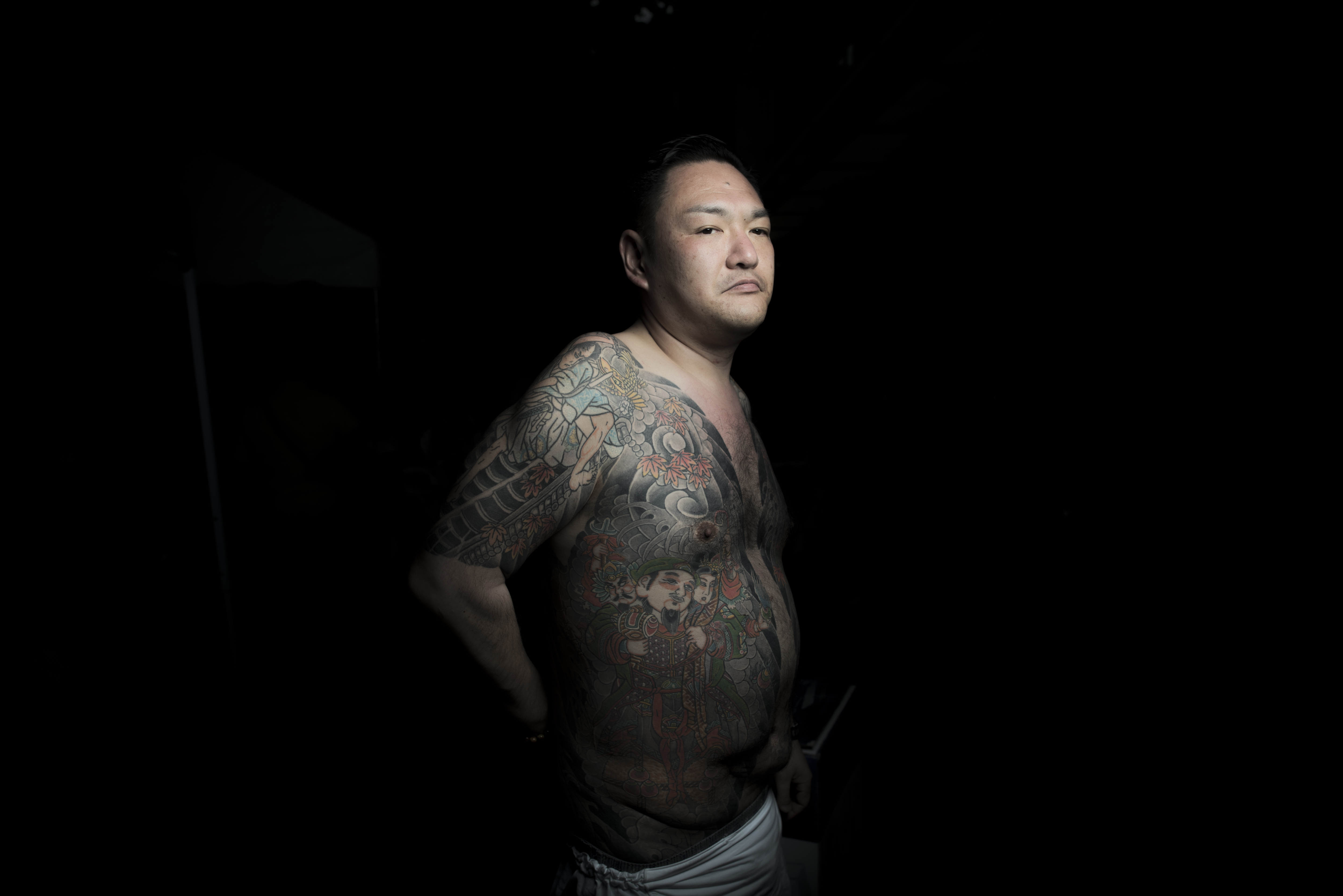 東京の三社祭で伝統的な刺青を見せる男性/FRED DUFOUR/AFP/AFP/Getty Images