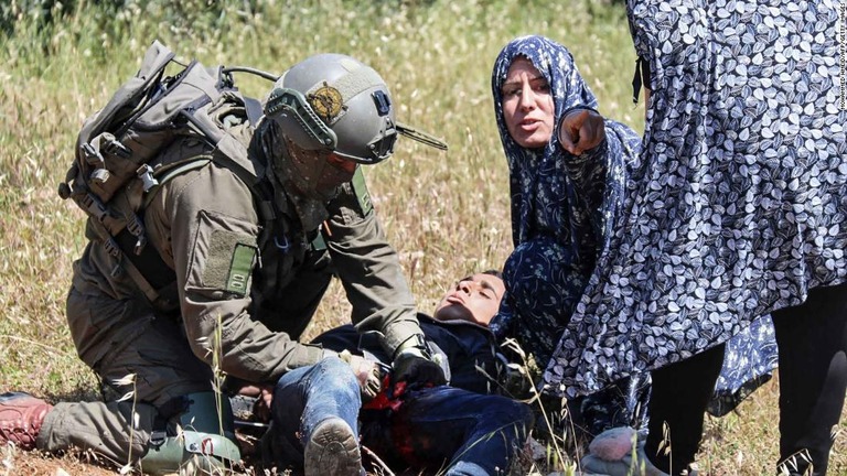 銃撃直後、兵士は少年を拘束して手当てを施した/Mohammed Hmeid/AFP/Getty Images