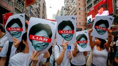 林鄭月娥（キャリー・ラム）行政長官を批判したポスターを掲げる人たち＝６月９日