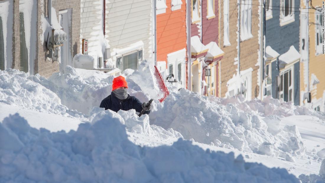 歩道の雪かきをする男性＝１８日、セントジョンズ市/Andrew Vaughan/The Canadian Press via AP