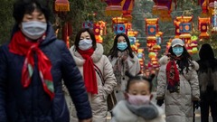 旧正月を迎えるなかマスクで予防する人たち＝北京