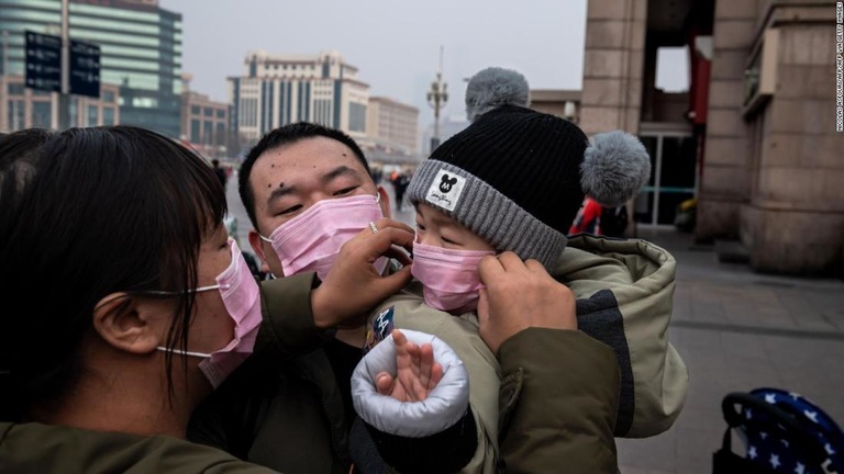 感染防止のためマスクをつける親子＝２７日、北京/NICOLAS ASFOURI/AFP/AFP via Getty Images