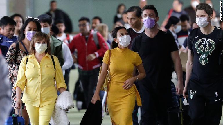 マニラ国際空港に降り立った人たち＝１月２３日/Aaron Favila/AP