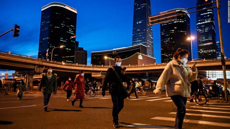 マスクを着けて北京市内を歩く会社員。中国系オーストラリア人が自主隔離を無視してジョギングを行ったことで解雇処分となったほか国外退去の指示を受けた/Kevin Frayer/Getty Images
