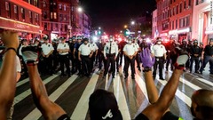 警官隊の前で片膝をつく人々＝６月４日、ニューヨーク市ブルックリン