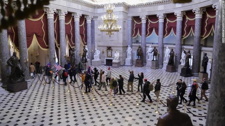 議事堂彫像ホールを行進するトランプ氏支持者/Erin Scott/Bloomberg/Getty Images