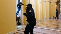 議事堂に入ろうとする人物に噴射を浴びせる議会警察の警官