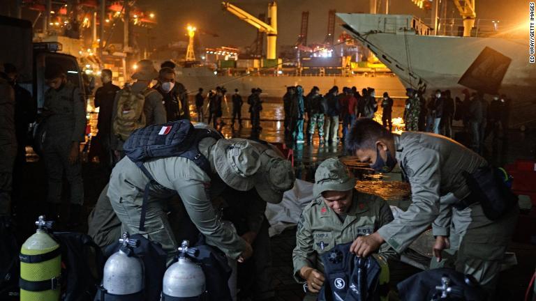 インドネシア警察のダイバーが捜索・救助活動の前に装備の点検を行う＝９日/Ed Wray/Getty Images